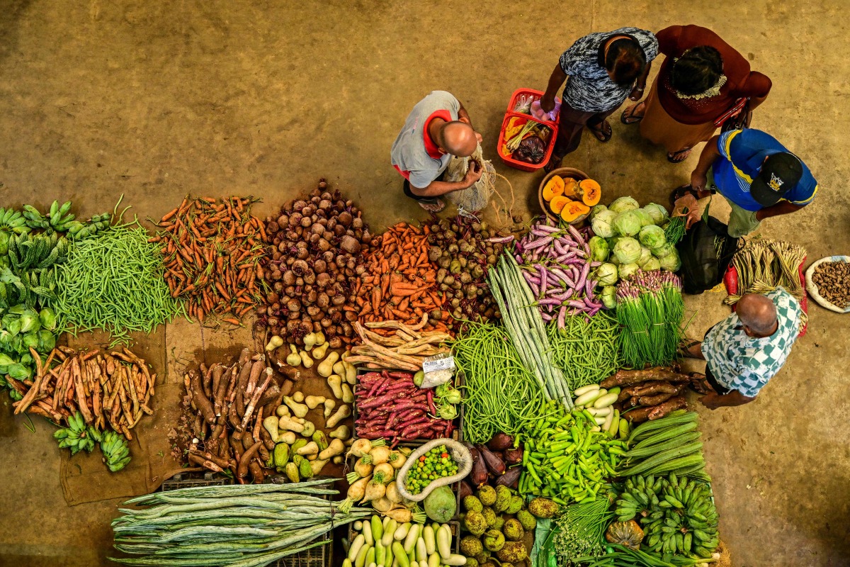 People buy vegetables at a market in Colombo on February 17, 2025. (Photo by Ishara S. KODIKARA / AFP)