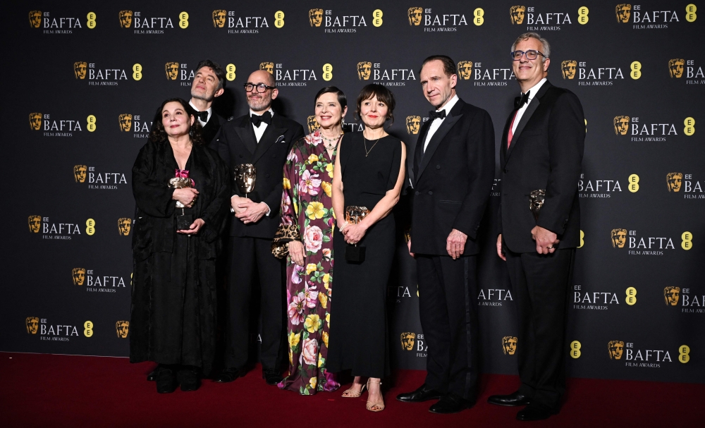 British German director Edward Berger (3L) Italian actor Isabella Rossellini (4L) and British actor Ralph Fiennes (2R) pose with the award for Best film for 