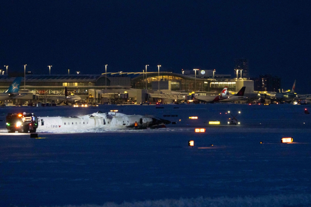 A Delta Airlines plane lies overturned after crashing earlier in the day at Toronto Pearson International Airport on February 17, 2025 in Toronto, Canada. Katherine KY Cheng/Getty Images/AFP