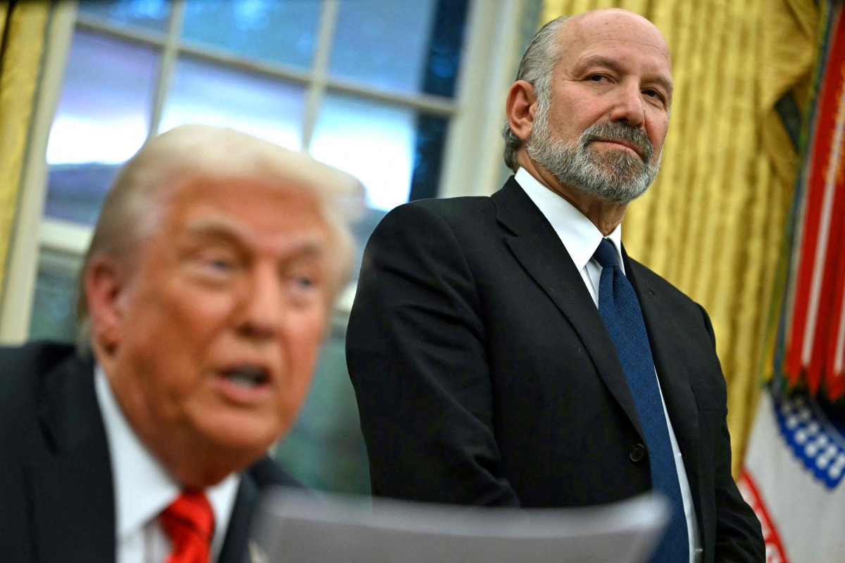 (FILES) US President Donald Trump speaks to the press after signing an executive order, alongside US Secretary of Commerce nominee Howard Lutnick (R), in the Oval Office of the White House in Washington, DC, on February 10, 2025. (Photo by ANDREW CABALLERO-REYNOLDS / AFP)
