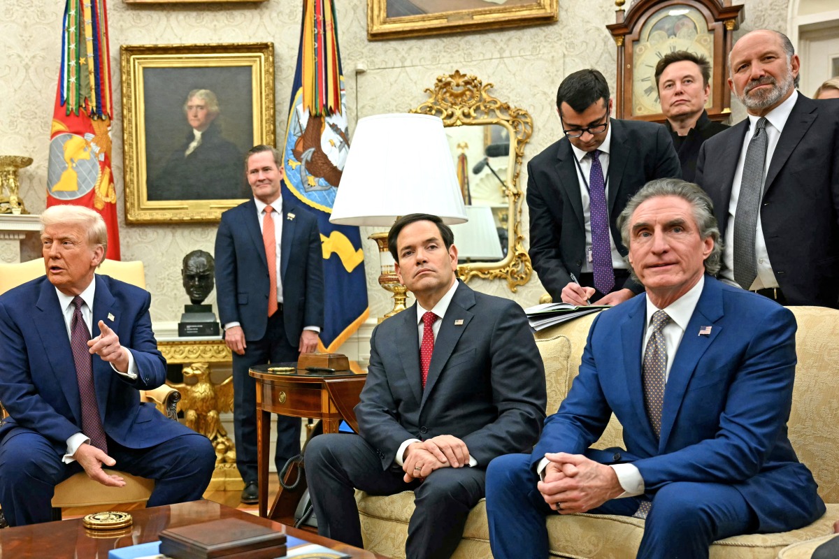 US President Donald Trump speaks with the press as he meets with unseen Indian Prime Minister Narendra Modi, alongside US Secretary of State Marco Rubio (2nd R), US Secretary of the Interior Doug Burgum (R), Elon Musk (top C) and US Secretary of Commerce nominee Howard Lutnick (top R), in the Oval Office of the White House in Washington, DC, on February 13, 2025. (Photo by Jim WATSON / AFP)
