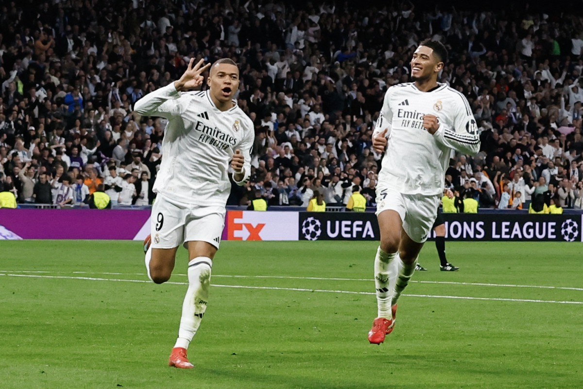 Real Madrid's French forward #09 Kylian Mbappe (C) celebrates scoring his third goal for a hat trick during the UEFA Champions League knockout phase play-off football match between Real Madrid CF and Manchester City at the Santiago Bernabeu stadium in Madrid on February 19, 2025. (Photo by OSCAR DEL POZO / AFP)
