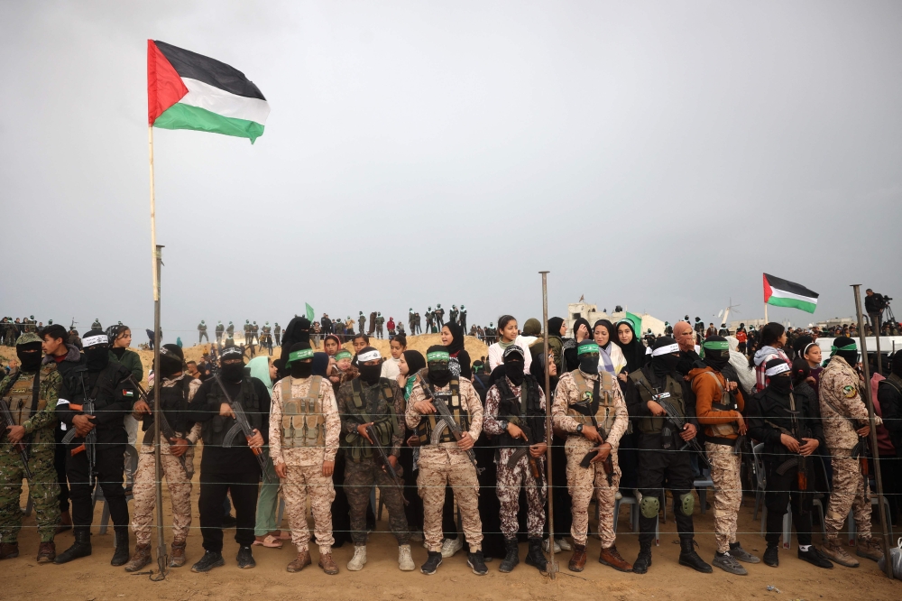 Hamas fighters ahead of the handing over the bodies of four Israeli hostages in Khan Yunis in the southern Gaza on February 20, 2025. (Photo by Eyad Baba / AFP)
 