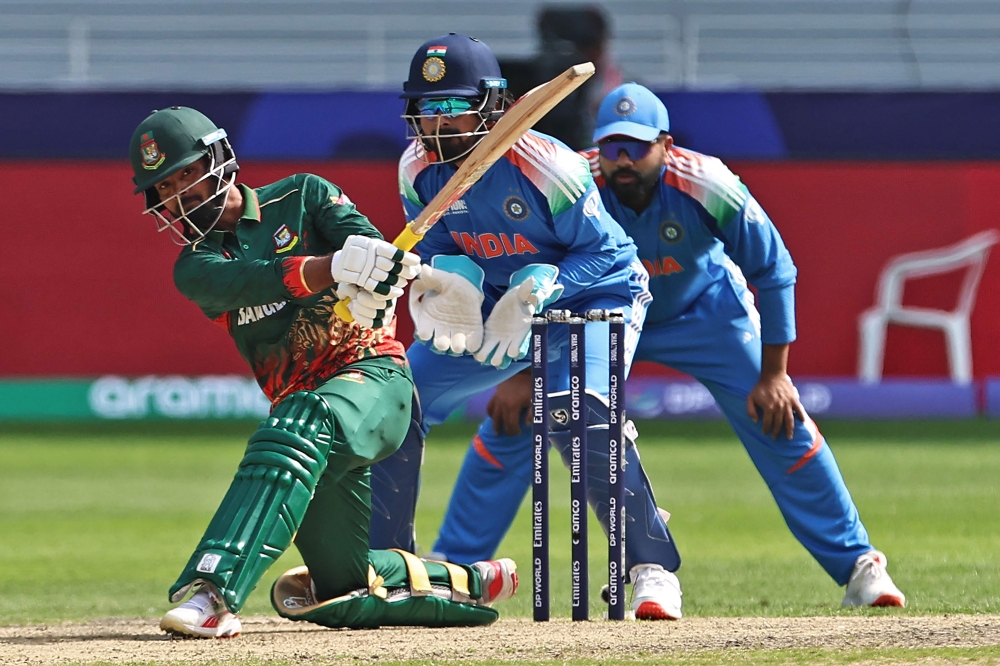 Bangladesh's Towhid Hridoy (L) plays a shot as India's wicketkeeper KL Rahul (C) watches during the ICC Champions Trophy one-day international (ODI) cricket match between Bangladesh and India at the Dubai International Stadium in Dubai on February 20, 2025. (Photo by Fadel Senna / AFP)