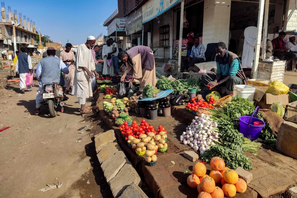 Street vendors sell their fruits and vegetables at a market in Wad Madani in Sudan's al-Jazira state on February 20, 2025. (Photo by AFP)