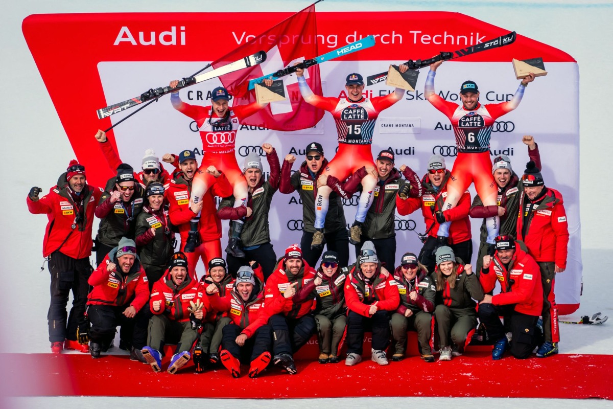 Second-placed Switzerland's Marco Odermatt, first-placed Switzerland's Franjo Von Allmen and third-placed Switzerland's Alexis Monney pose with their staff after the men's downhill event at the FIS Alpine Skiing World Cup in Crans-Montana on February 22, 2025. (Photo by maxime schmid / AFP)