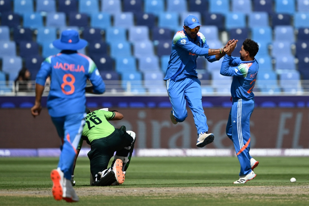 India's Axar Patel (2R) celebrates with Kuldeep Yadav (R) after taking the wicket of Pakistan's Imam-ul-Haq (2L) during the ICC Champions Trophy cricket match between Pakistan and India in Dubai on February 23, 2025. (Photo by Jewel Samad / AFP)