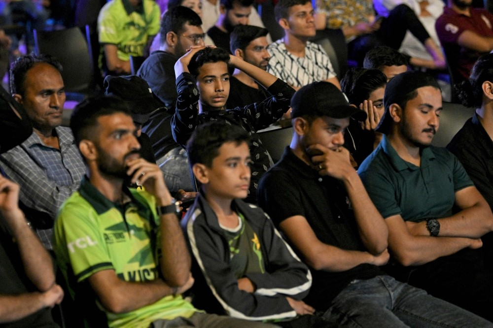 Pakistani cricket fans react as they watch a live broadcast of the ICC Champions Trophy one-day international (ODI) cricket match between India and Pakistan in Dubai, on a big screen in Karachi on February 23, 2025. (Photo by Asif Hassan / AFP)