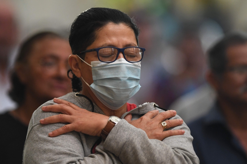 A catholic faithful prays during a mass for the healing of Pope Francis at San Miguel Arcangel Cathedral in Tegucigalpa on February 23, 2025. (Photo by Orlando Sierra / AFP)