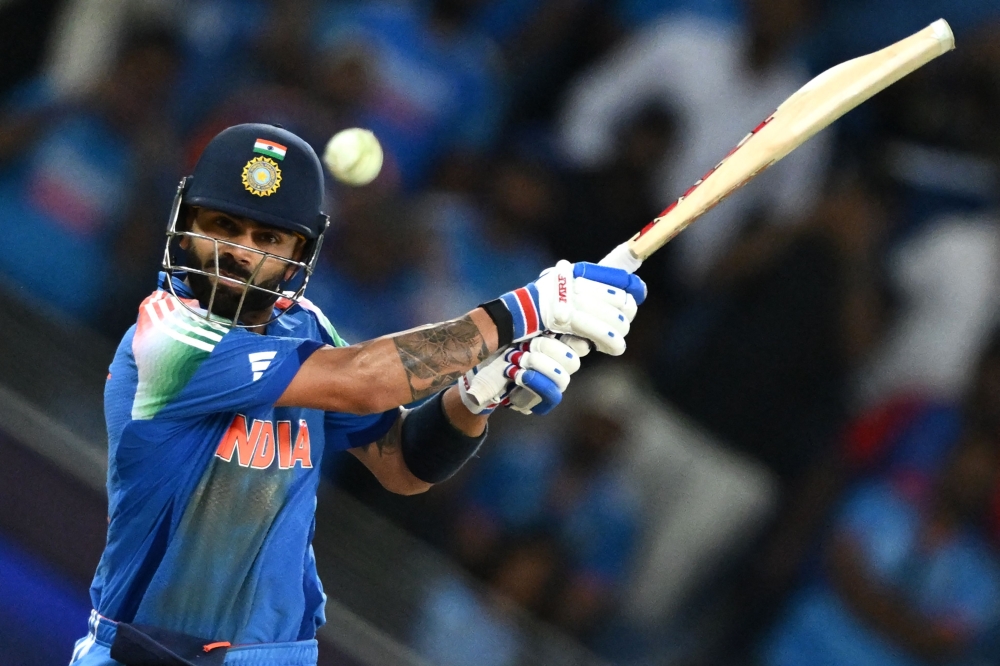 India's Virat Kohli hits the winning boundary and completes his century (100 runs) during the ICC Champions Trophy match between Pakistan and India in Dubai on February 23, 2025. (Photo by Jewel Samad / AFP)