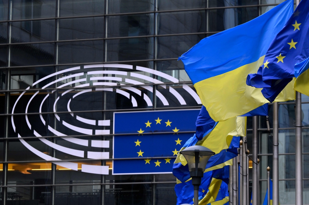 The European and Ukrainian flags are displayed in front of the Altiero-Spinelli building, the European Parliament in Brussels on February 24, 2025. (Photo by John Thys / AFP)