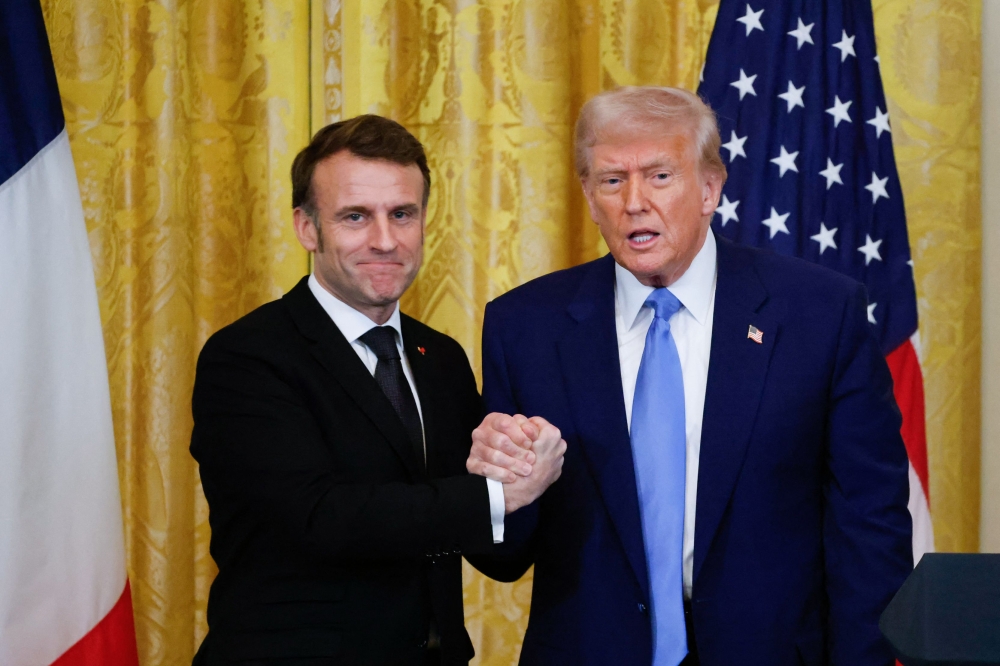 US President Donald Trump and French President Emmanuel Macron shake hands at the end of a joint press conference in the East Room to the White House in Washington, DC, on February 24, 2025. (Photo by Ludovic Marin / AFP)