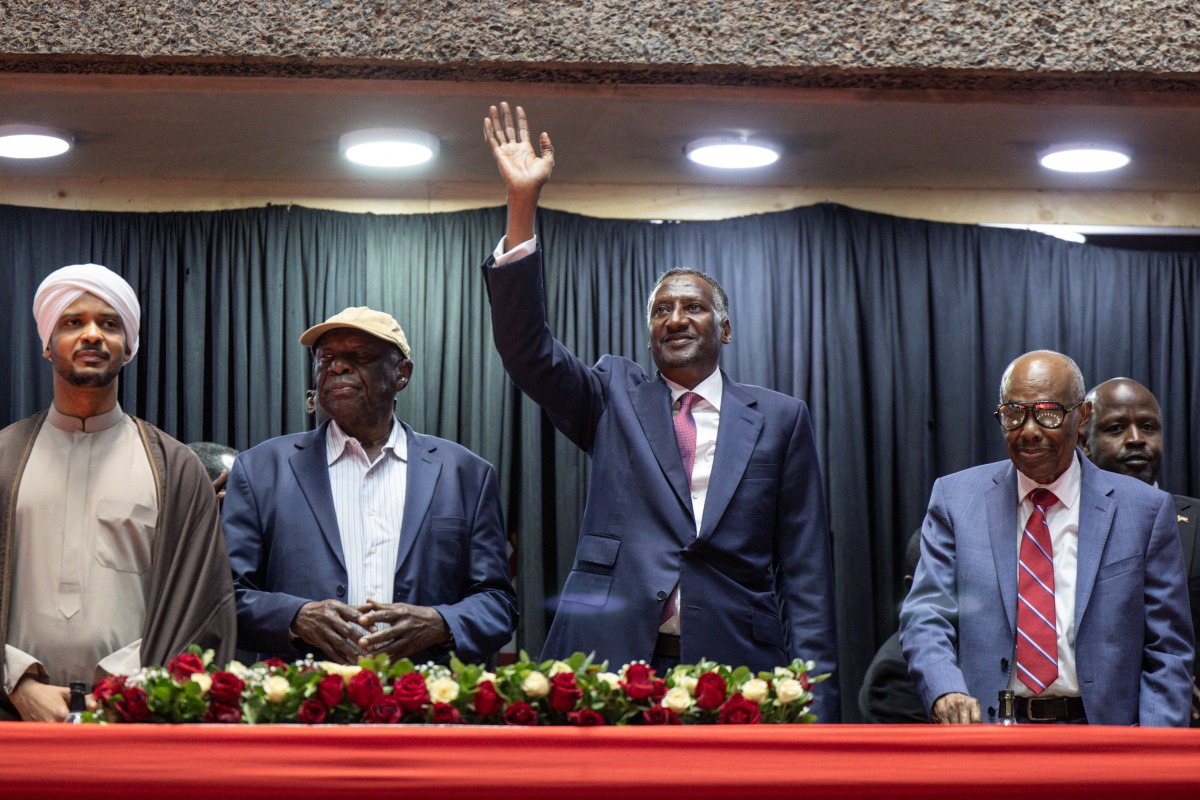 Abdul Rahim Hamdan Dagalo (C), Sudan's Rapid Support Forces (RSF) deputy commander and brother to Mohamed Hamdan Dagalo (also known as Hemedti), flanked by representatives of other political parties affiliated to Sudan's Rapid Support Forces react as they arrive at the venue ahead of their planned signing of the Government of Peace and Unity Charter, at the Kenyatta International Convention Centre (KICC) in Nairobi on February 18, 2025. (Photo by SIMON MAINA / AFP)