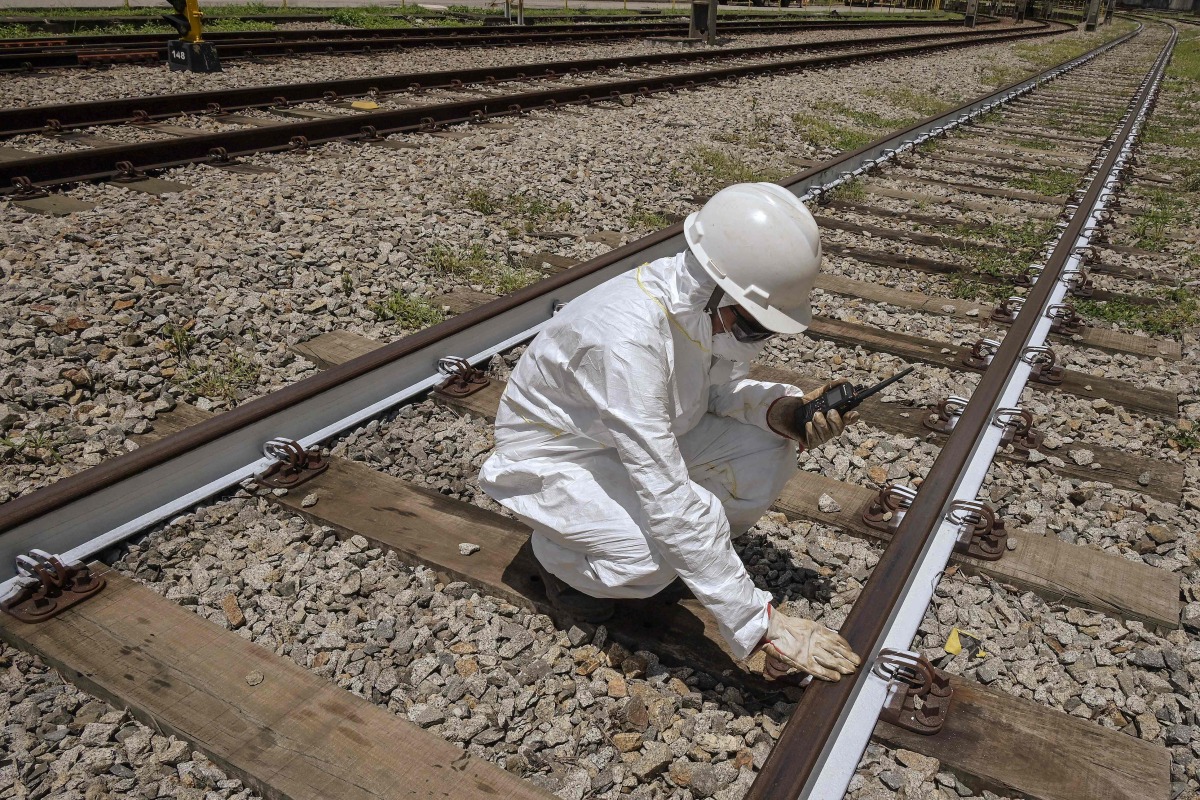 An Employee of ViaMobilidade - a company that manages subway and train lines in the Sao Paulo metropolitan area - takes the temperature of railway tracks in Osasco, Sao Paulo state, Brazil on February 24, 2025. (Photo by Nelson ALMEIDA / AFP)
