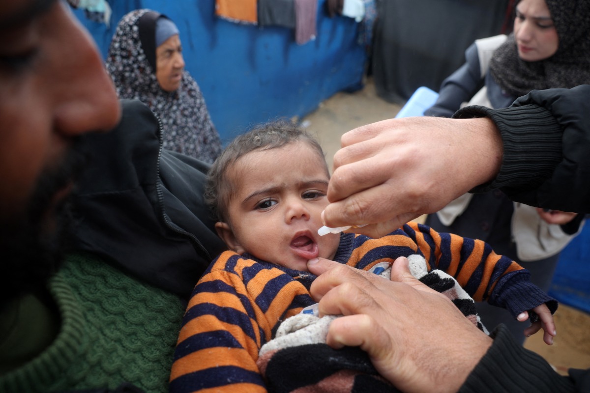 A Palestinian child receives a polio vaccine at a camp for displaced people in Nuseirat in the central Gaza Strip on February 23, 2025. Photo by Eyad BABA / AFP