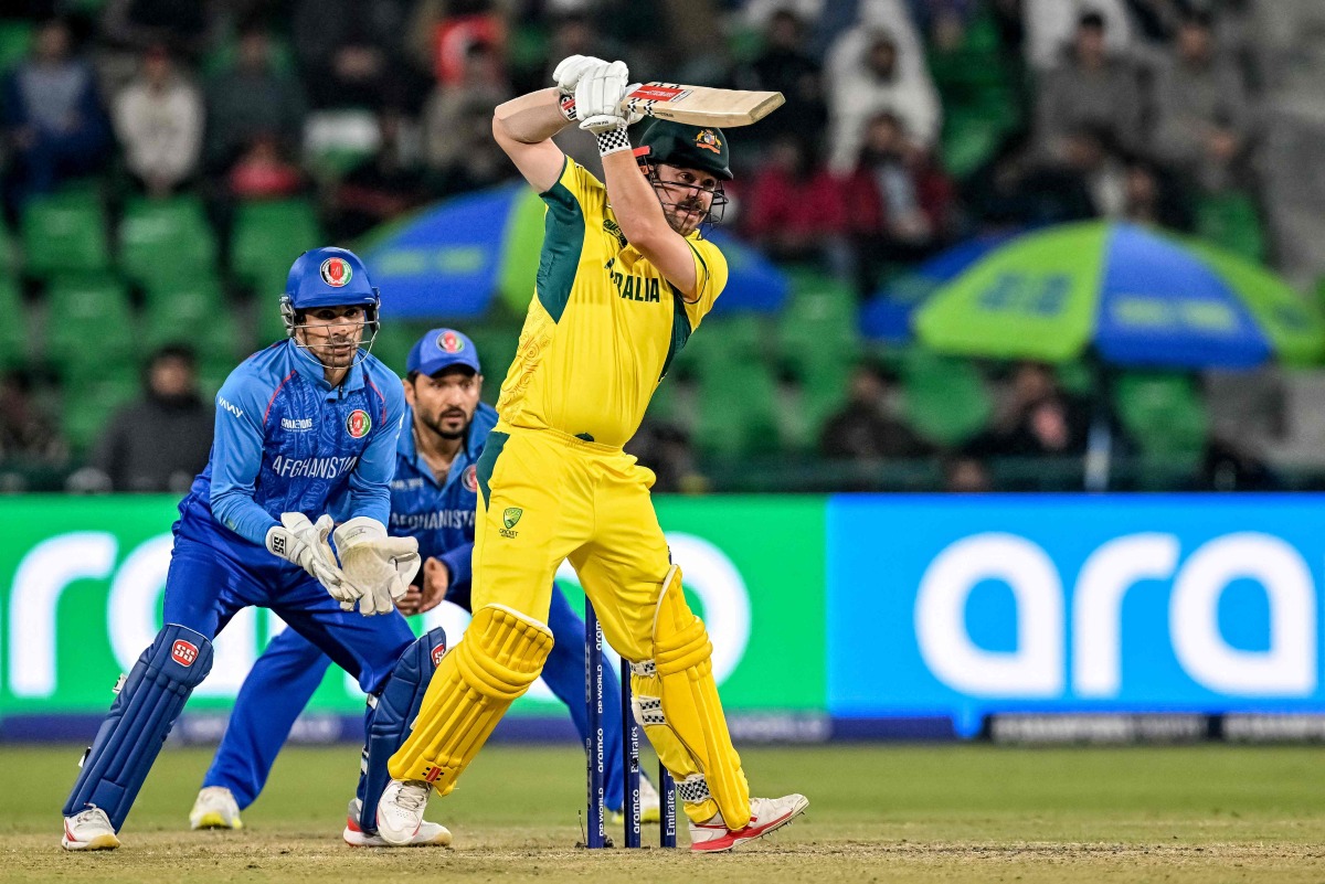 Australia's Travis Head (R) plays a shot during the ICC Champions Trophy one-day international (ODI) cricket match between Australia and Afghanistan at the Gaddafi Stadium in Lahore on February 28, 2025. (Photo by Aamir QURESHI / AFP)
