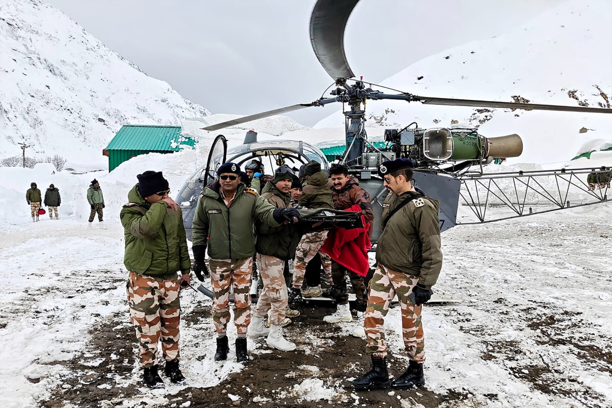 In this handout photograph taken on March 1, 2025 and released by the Department of Information and Public Relations (DIPR) Uttarakhand, security personnel carry a victim onto a helicopter during a rescue operation, a day after an avalanche hit a Border Roads Organisation (BRO) construction camp, as workers remain trapped under snow and debris near Mana village in the Chamoli district of India's Uttarakhand state. Photo by Department of Information and Public Relations (DIPR) Uttarakhand / AFP