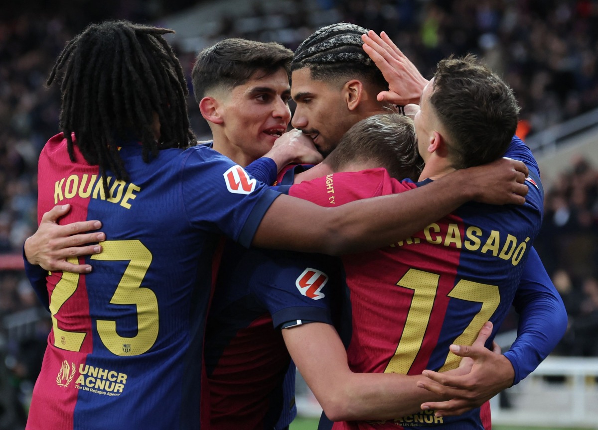 Barcelona's Uruguayan defender #04 Ronald Federico Araujo da Silva (C) celebrates scoring his team's third goal during the Spanish league football match between FC Barcelona and Real Sociedad at Estadi Olimpic Lluis Companys in Barcelona on March 2, 2025. (Photo by LLUIS GENE / AFP)
