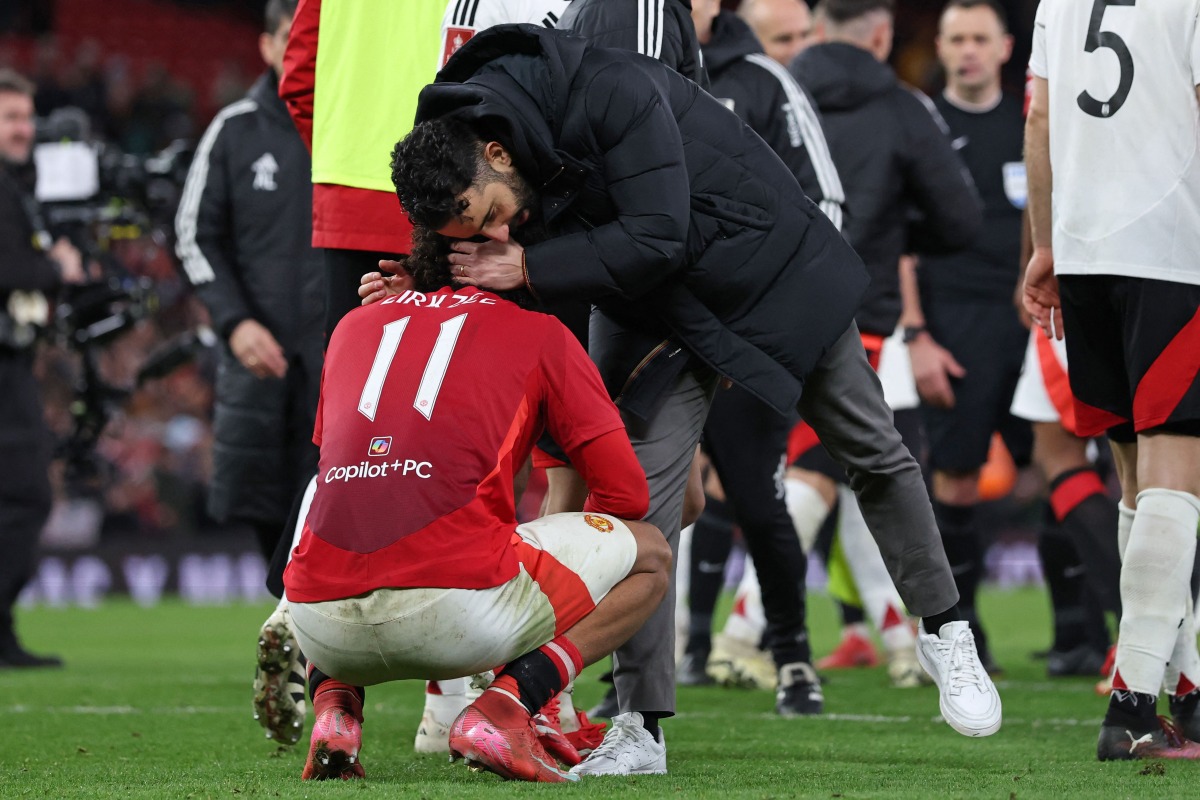 Manchester United's Dutch striker #11 Joshua Zirkzee is consoled by Manchester United's Portuguese head coach Ruben Amorim after missing the final penalty in the penalty shoot-out in the English FA Cup fifth round football match between Manchester United and Fulham at Old Trafford in Manchester, north west England, on March 2, 2025. (Photo by Darren Staples / AFP)