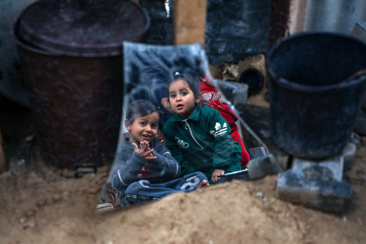 Karam Haloub's kids are seen near their damaged house in Beit Lahia in the northern Gaza Strip, on March 3, 2025. (Photo by Rizek Abdeljawad/Xinhua)
