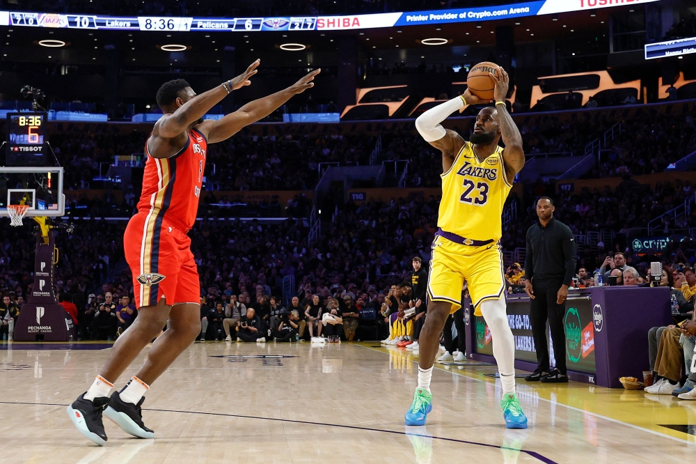 LeBron James #23 of the Los Angeles Lakers shoots a 3-point basket to score his 50,002 NBA regular season and playoff career points during the first half against Zion Williamson #1 of the New Orleans Pelicans at Crypto.com Arena on March 04, 2025 in Los Angeles, California. Ronald Martinez/Getty Images/AFP 
 