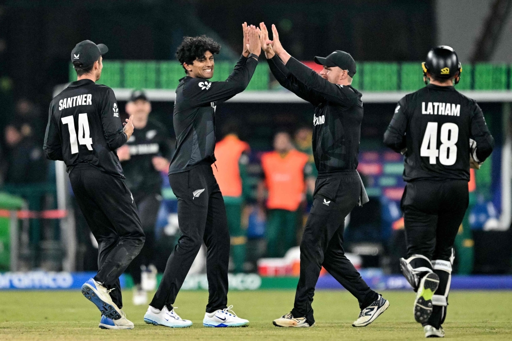 New Zealand's Rachin Ravindra (second left) celebrates with teammates after taking a catch to dismiss South Africa's Aiden Markram during the ICC Champions Trophy one-day international (ODI) semi-final cricket match between New Zealand and South Africa at the Gaddafi Stadium in Lahore on March 5, 2025. (Photo by Asif Hassan / AFP)
