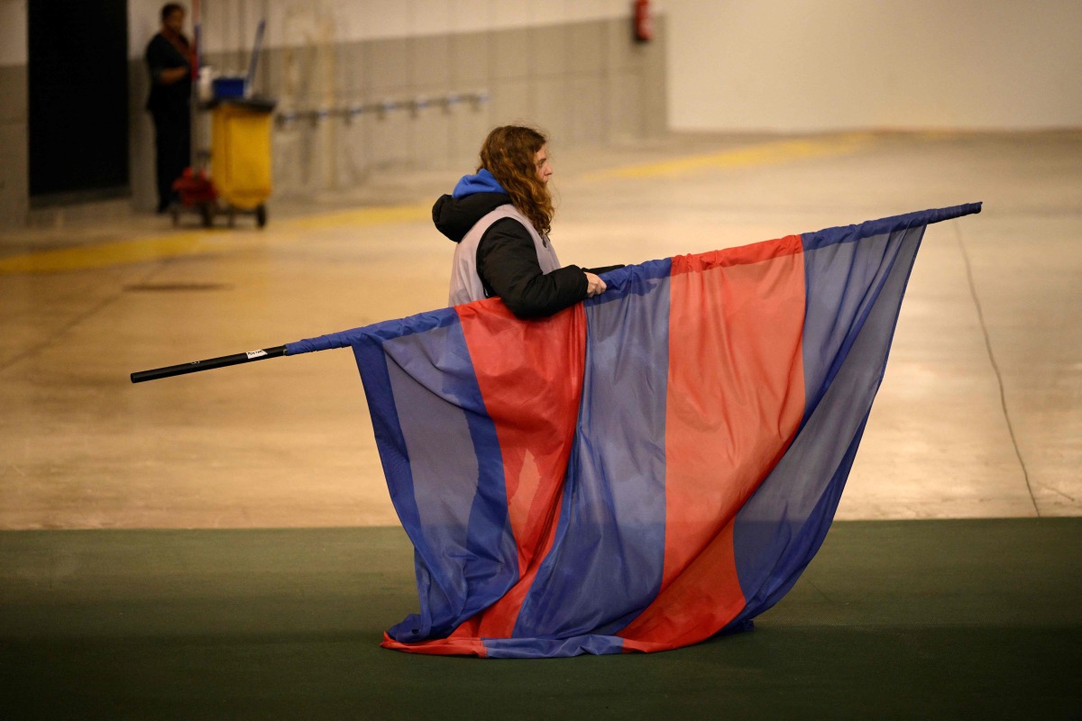 A staff member takes away the FC Barcelona's flag following the decision to cancel the Spanish league football match between FC Barcelona and CA Osasuna at Estadi Olimpic Lluis Companys in Barcelona on March 8, 2025. (Photo by Josep LAGO / AFP)
