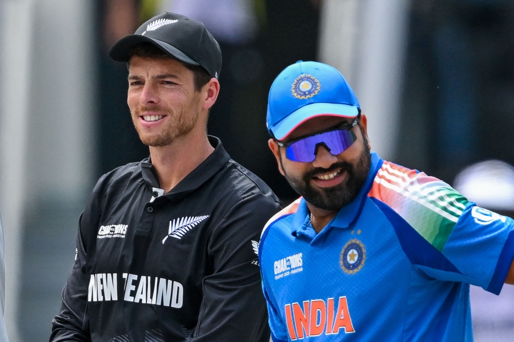 India's captain Rohit Sharma (R) and his New Zealand's counterpart Mitchell Santner arrive at the field for the toss at the Dubai International Stadium in Dubai on March 9, 2025. (Photo by Ryan Lim / AFP)