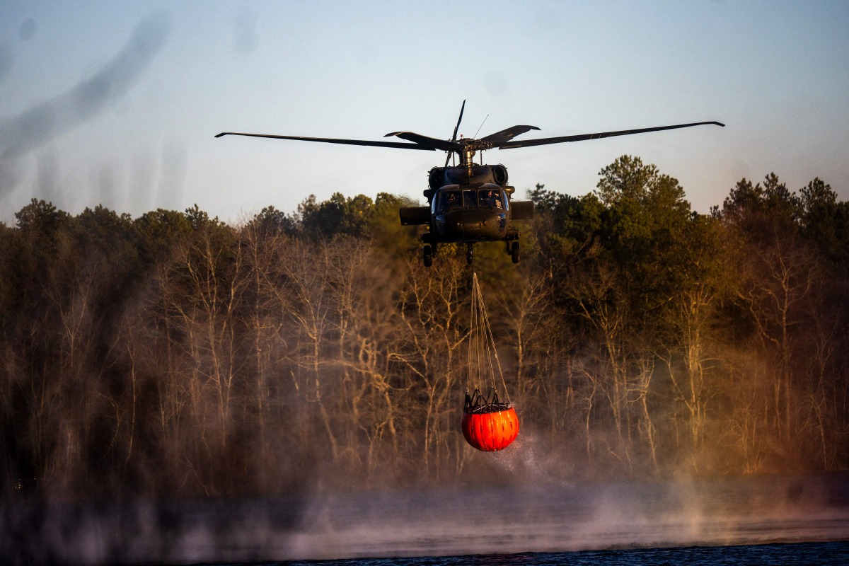 A rescue helicopter picks up water at Wild Wood Lake on March 8, 2025 in Westhampton, New York. Photo by Andrew Theodorakis / GETTY IMAGES NORTH AMERICA / Getty Images via AFP