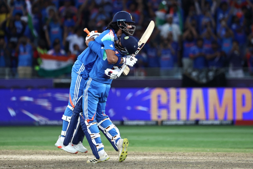 India's KL Rahul (left) and Ravindra Jadeja celebrate their victory at the end of the ICC Champions Trophy one-day international (ODI) final cricket match between India and New Zealand at the Dubai International Stadium in Dubai on March 9, 2025. (Photo by Fadel Senna / AFP)