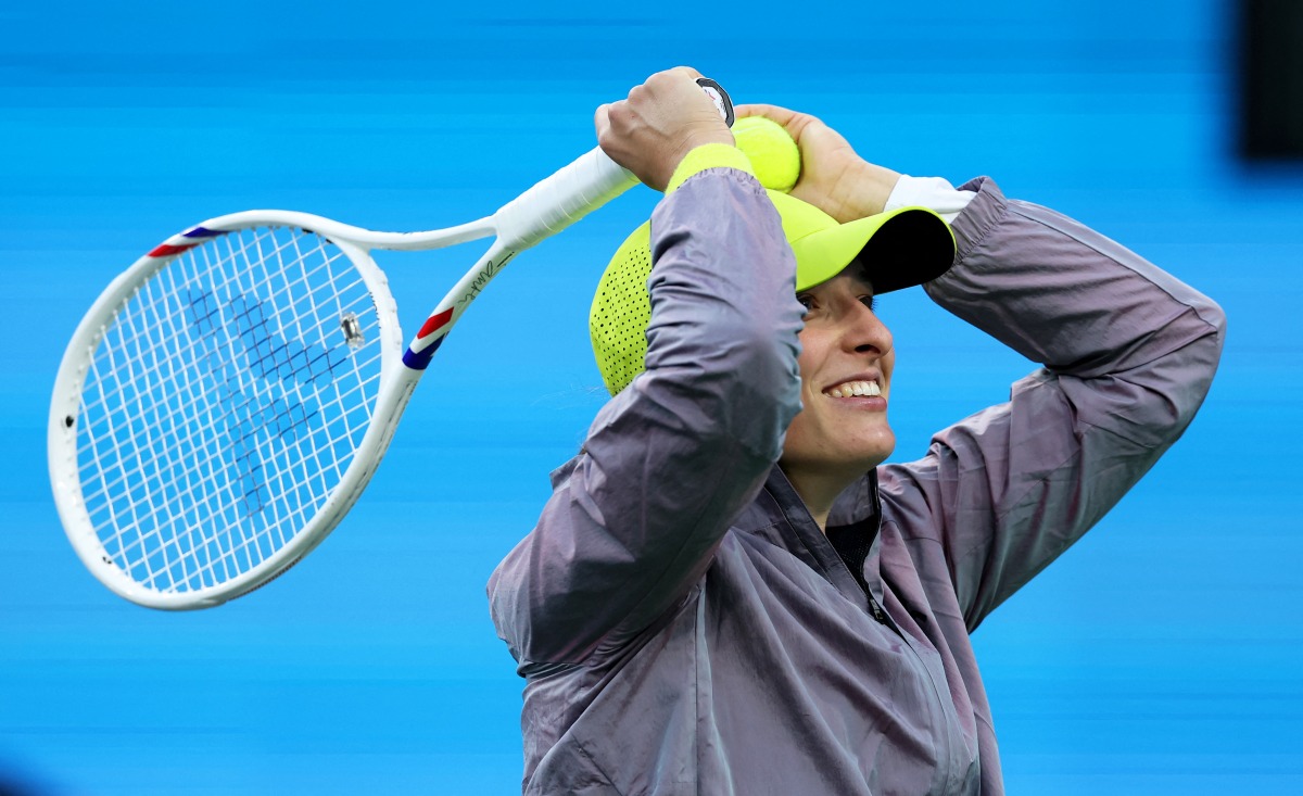  Iga Swiatek of Poland hits autographed balls into the crow after her straight sets victory against Caroline Garcia of France in their second round match during the BNP Paribas Open at Indian Wells Tennis Garden on March 07, 2025 in Indian Wells, California. (Photo by CLIVE BRUNSKILL / GETTY IMAGES NORTH AMERICA / Getty Images via AFP)