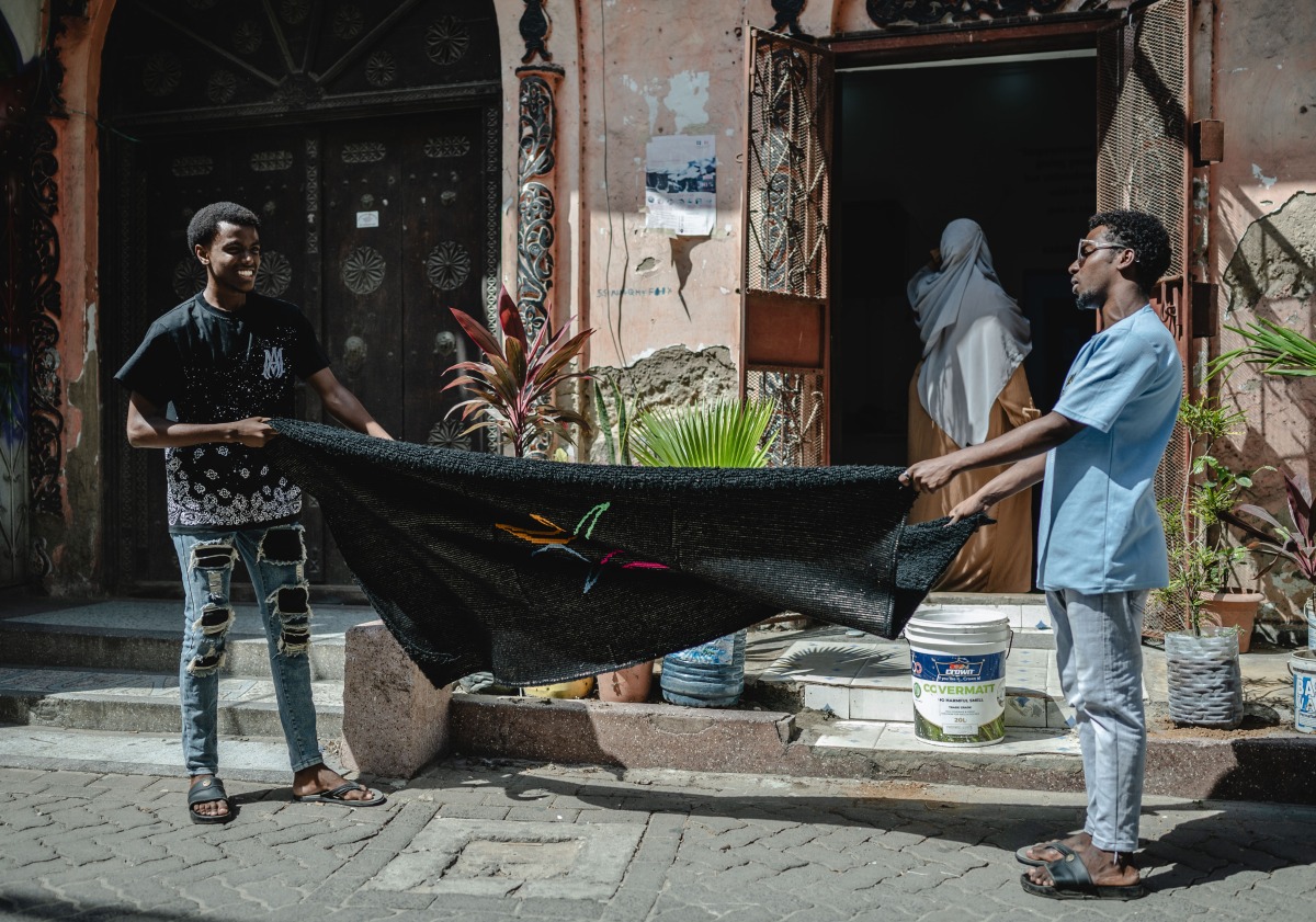 People clean a carpet in the Old Town of Mombasa, Kenya, on Aug. 17, 2024. (Xinhua/Wang Guansen)
