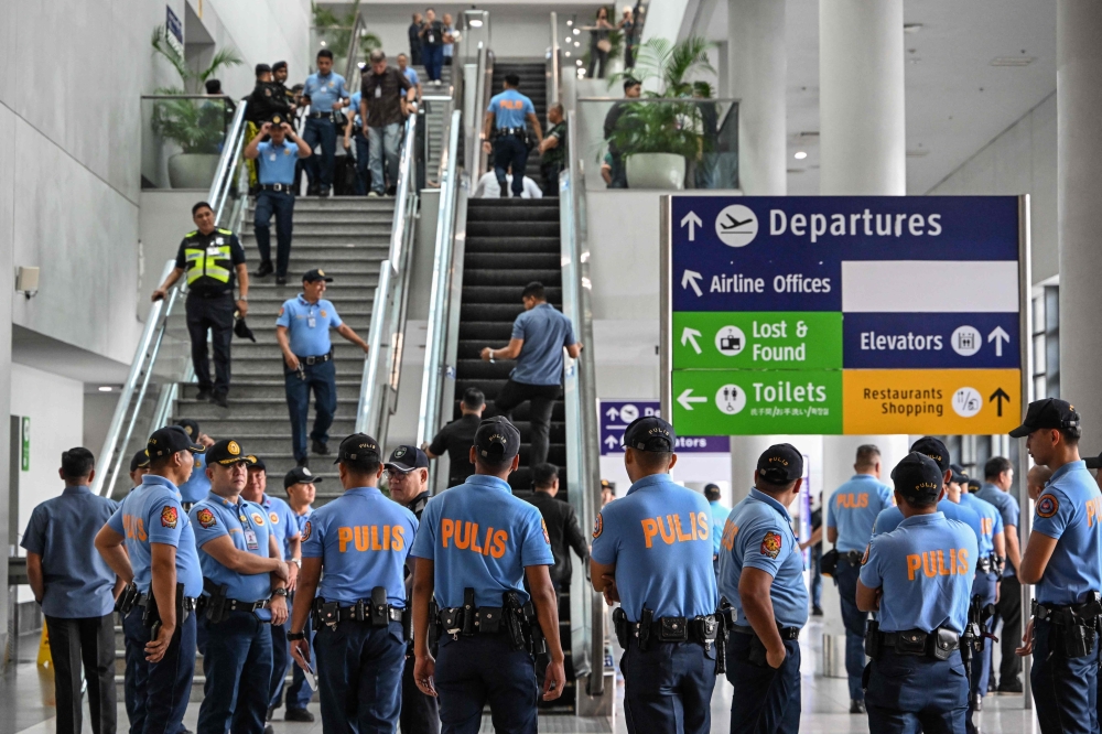 Policemen gather as they wait for the arrival of former Philippine president Rodrigo Duterte at Ninoy Aquino International Airport in Pasay, metro Manila on March 11, 2025. (Photo by Jam Sta Rosa / AFP)