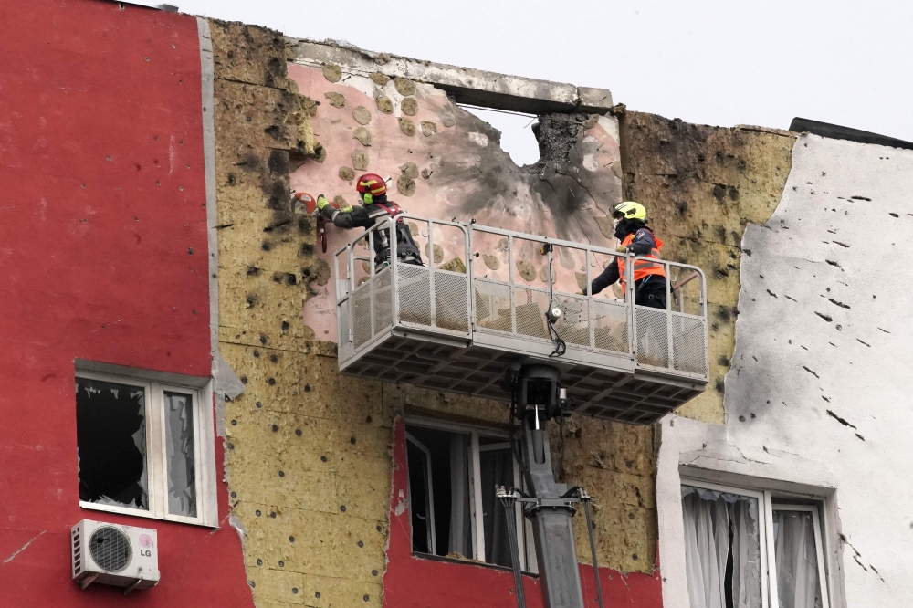 Specialists work on the facade of a damaged apartment building following a drone attack in Moscow on March 11, 2025. (Photo by Tatyana Makeyeva / AFP)