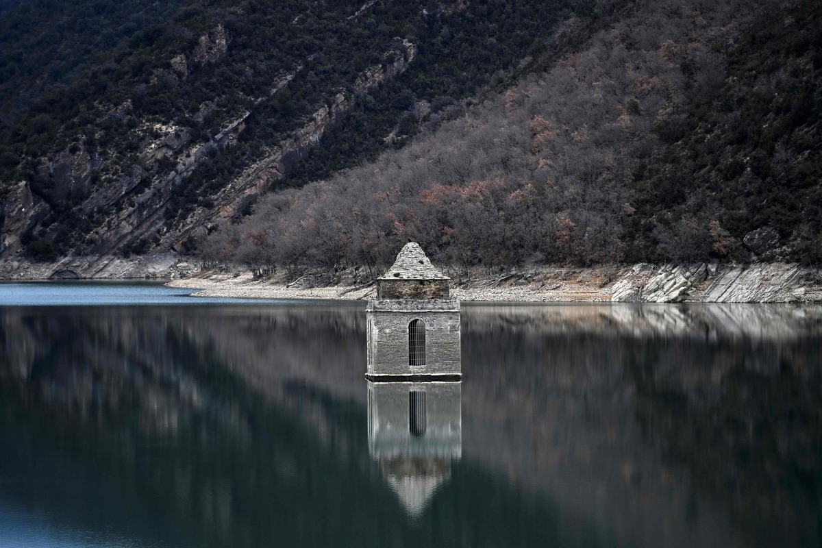 This photograph taken on January 21, 2025 shows a view of the Mediano reservoir, with the Church of Asuncion of Mediano visible due to the low water-level, in Mediano, Huesca province. Photo by ANDER GILLENEA / AFP