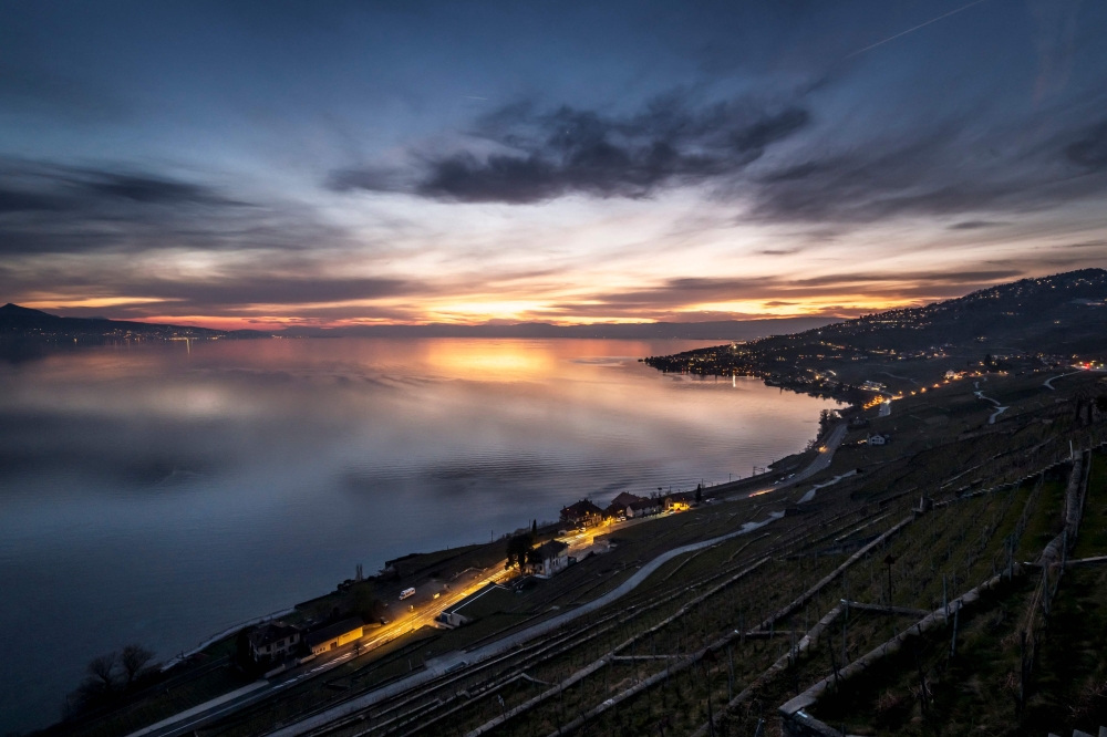 This photograph shows the Lake Geneva after sunset above the vineyard terraces of Lavaux, near Chexbres, western Swizterland, on March 6, 2025. (Photo by Fabrice Coffrini / AFP)