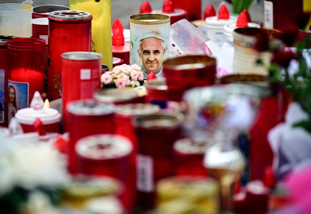 Candles are laid at the Gemelli hospital where Pope Francis is hospitalized with pneumonia, in Rome on March 17, 2025. (Photo by Tiziana FABI / AFP)