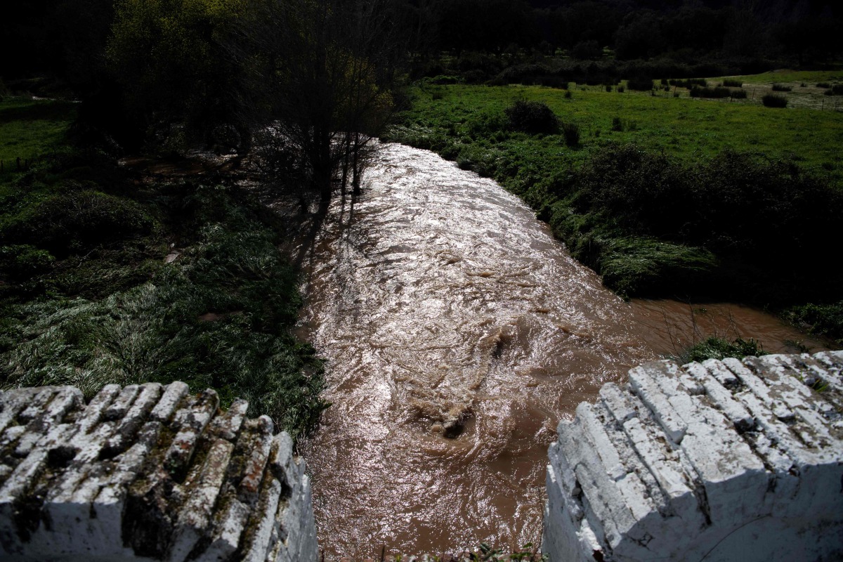 A picture taken on March 18, 2025 shows a swollen stream following storms near Constantina, north of Seville. Photo by CRISTINA QUICLER / AFP