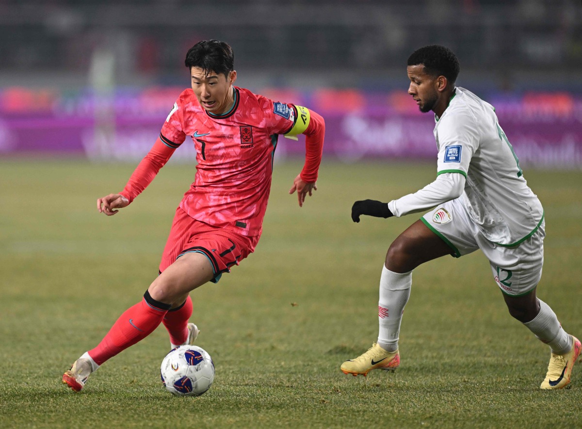 South Korea's Son Heung-min (L) competes for the ball with Oman's Abdullah Al-Harthi (R) during the World Cup 2026 Asian qualifier football match between South Korea and Oman in Goyang on March 20, 2025. (Photo by Jung Yeon-je / AFP)
 