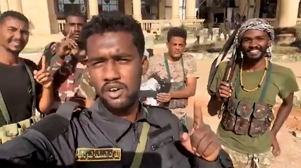 This image grab from a UGC video posted on March 21, 2025 shows Sudanese soldiers celebrating after retaking the presidential palace in Khartoum from paramilitaries. (Photo by UGC / AFP) 