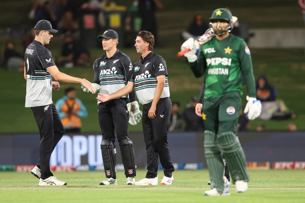 New Zealand's Zakary Foulkes (C) celebrates with Will O'Rourke (L) and Mitchell Hay after taking the wicket of Pakistan's Shaheen Shah Afridi during the fourth Twenty20 international cricket match between New Zealand and Pakistan at Bay Oval in Mount Maunganui on March 23, 2025. (Photo by Michael Bradley / AFP)