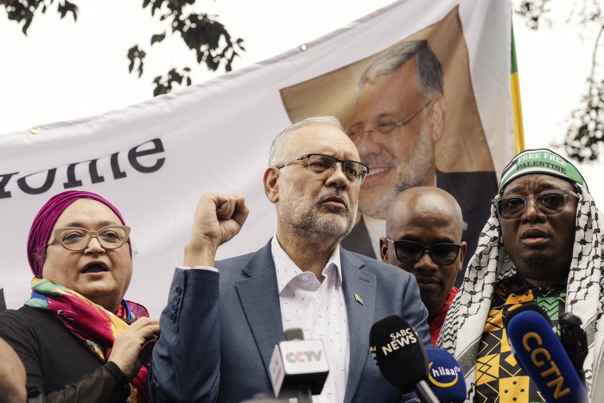 Former South African Ambassador to the United States Ebrahim Rasool (c), addresses supporters upon his arrival at the Cape Town International airport, in Cape Town, on March 23, 2025. Photo by GIANLUIGI GUERCIA / AFP.