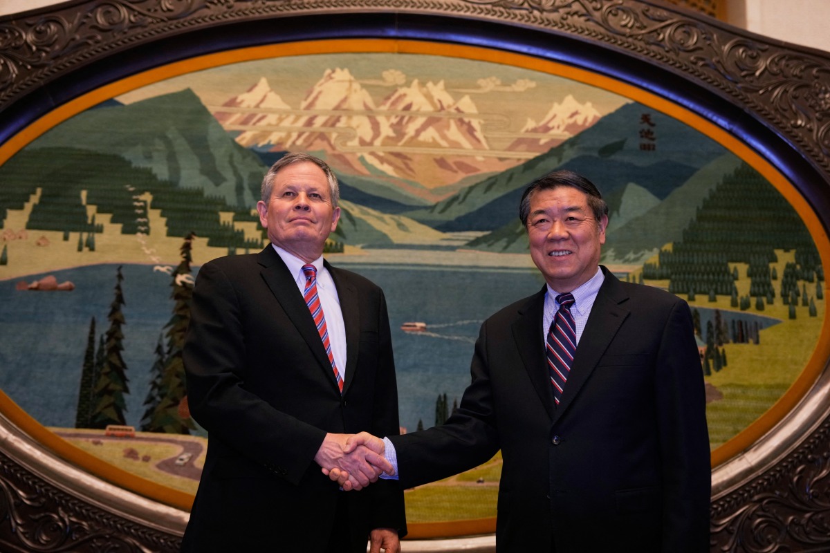 Chinese Vice Premier He Lifeng (R) shakes hands with US Senator Steve Daines before a meeting held in the Xinjiang Room at the Great Hall of the People in Beijing on March 22, 2025. Photo by Ng Han Guan / POOL / AFP.
