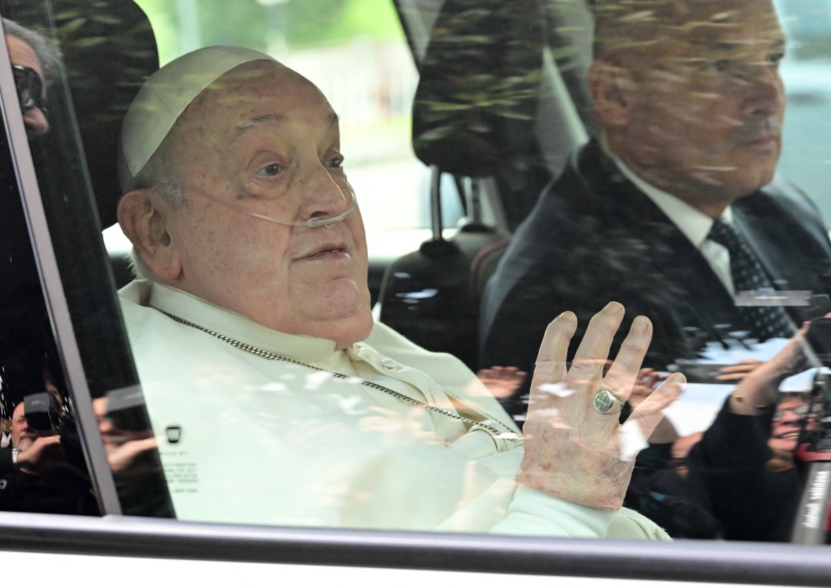 Pope Francis waves as he leaves the Gemelli hospital after a five weeks hospitalization for pneumonia, in Rome on March 23, 2025. Photo by Tiziana FABI / AFP.