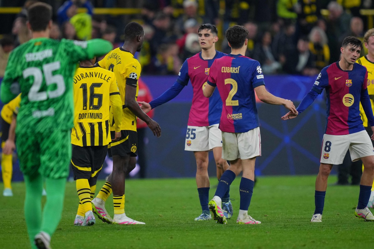 Players including Barcelona's Spanish defender #35 Gerard Martin (C) react after the UEFA Champions League quarter-final second leg football match between BVB Borussia Dortmund and FC Barcelona in Dortmund, western Germany on April 15, 2025. (Photo by Pau BARRENA / AFP)
